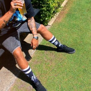man in black and white nike shoes sitting on green grass field during daytime